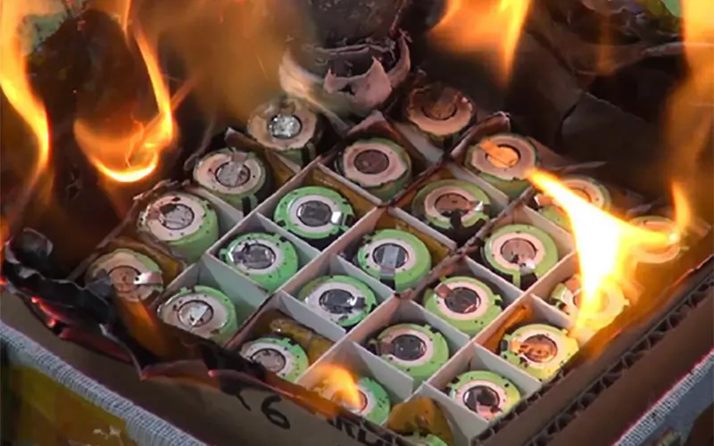 Gros plan sur une batterie lithium-ion en surchauffe dégageant des fumées toxiques